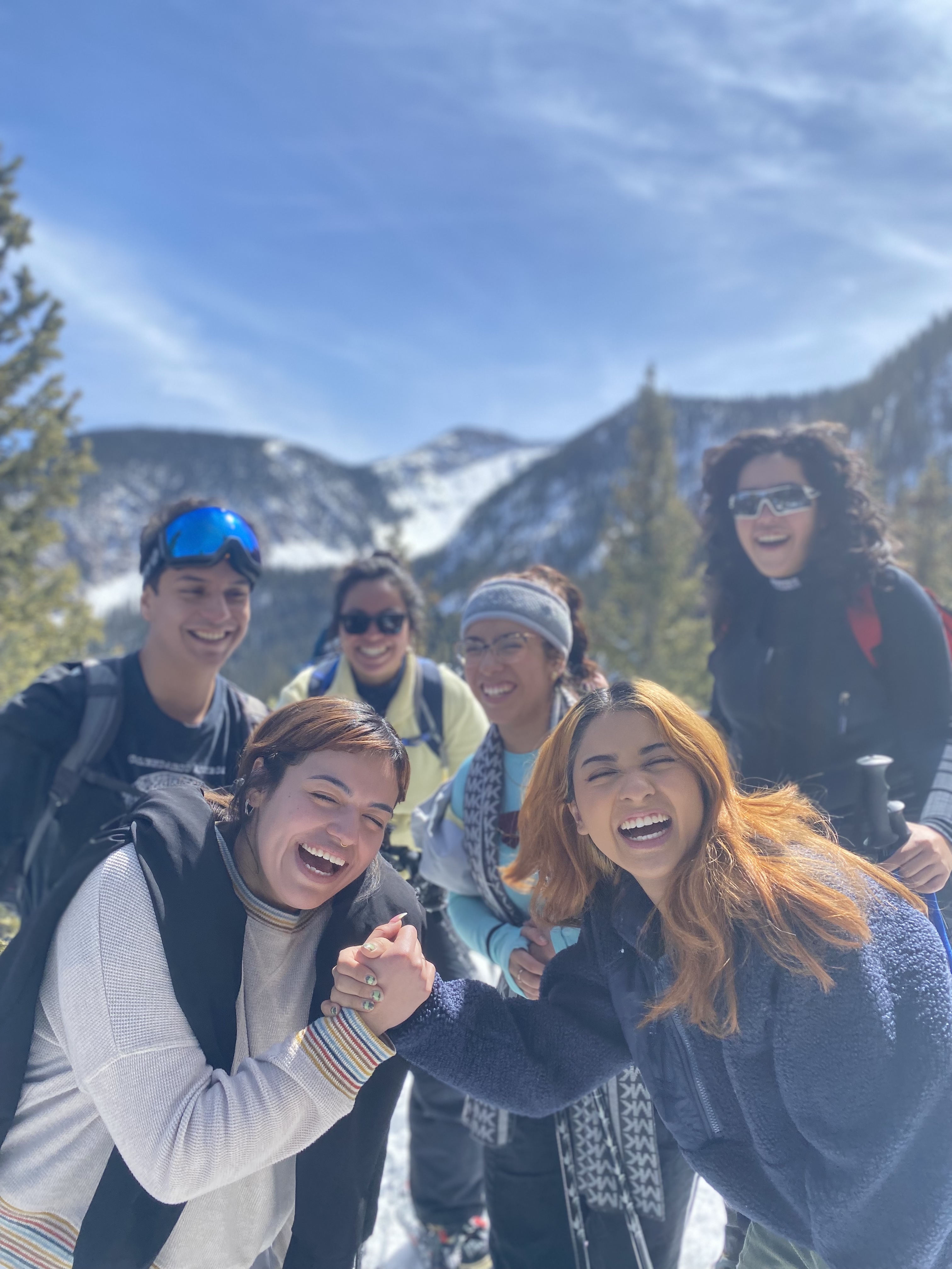 Young people hold hands and smile while looking at the camera